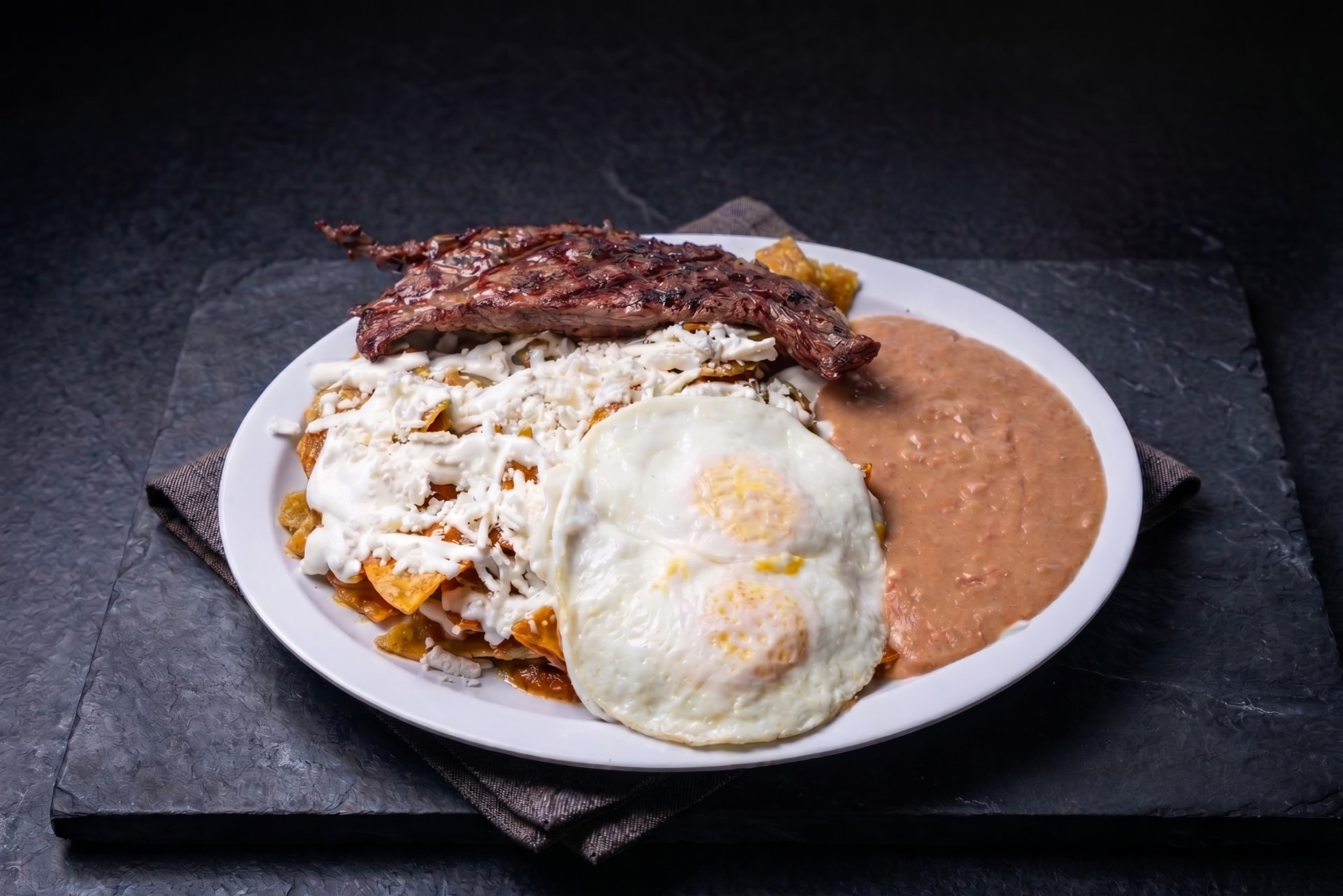 Chilaquiles con tasajo, huevo y queso fresco