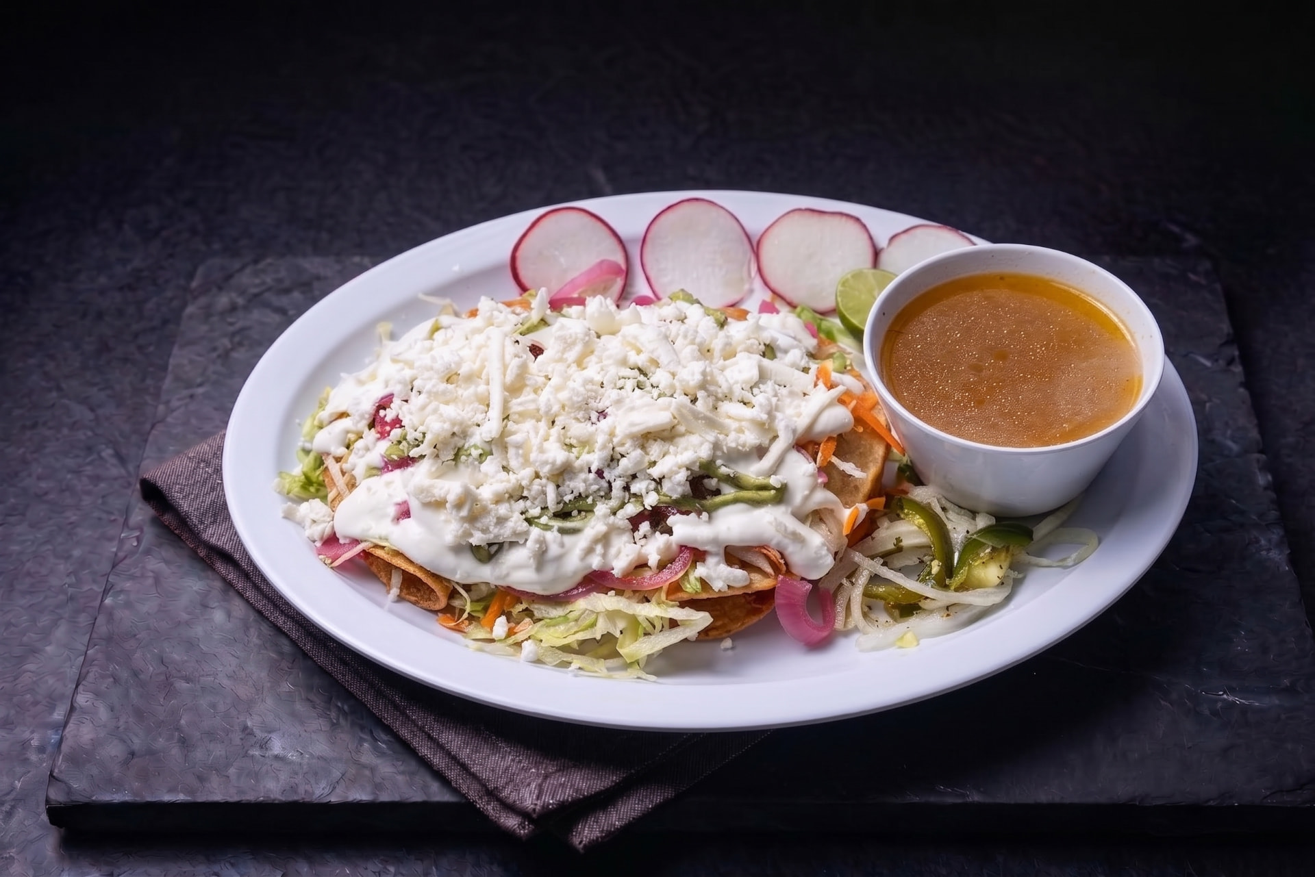 Tacos de papa o deshebrada dorados con queso fresco, crema, lechuga y salsa