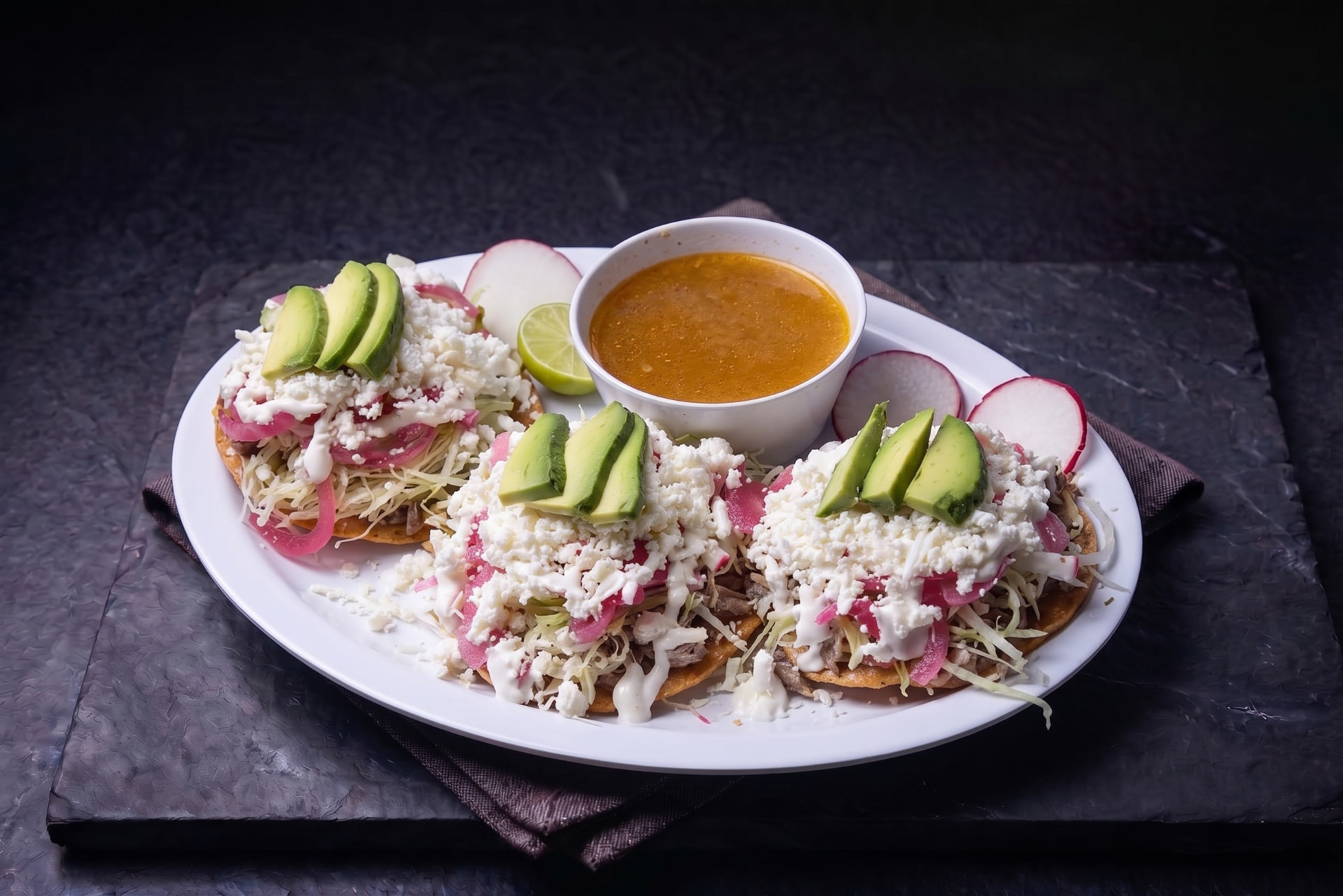 Tostada de carne deshebrada con aguacate, queso fresco y salsa