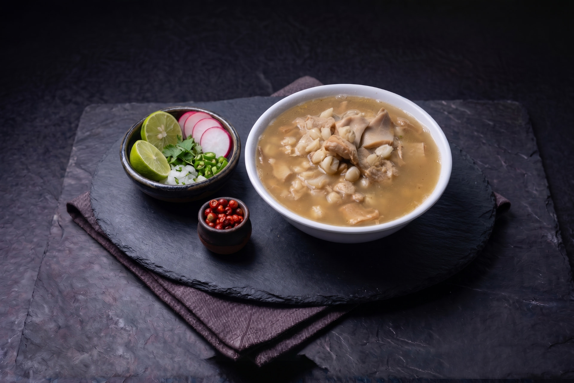 Menudo blanco estilo Sinaloa servido con limón, rábano, cebolla y chile