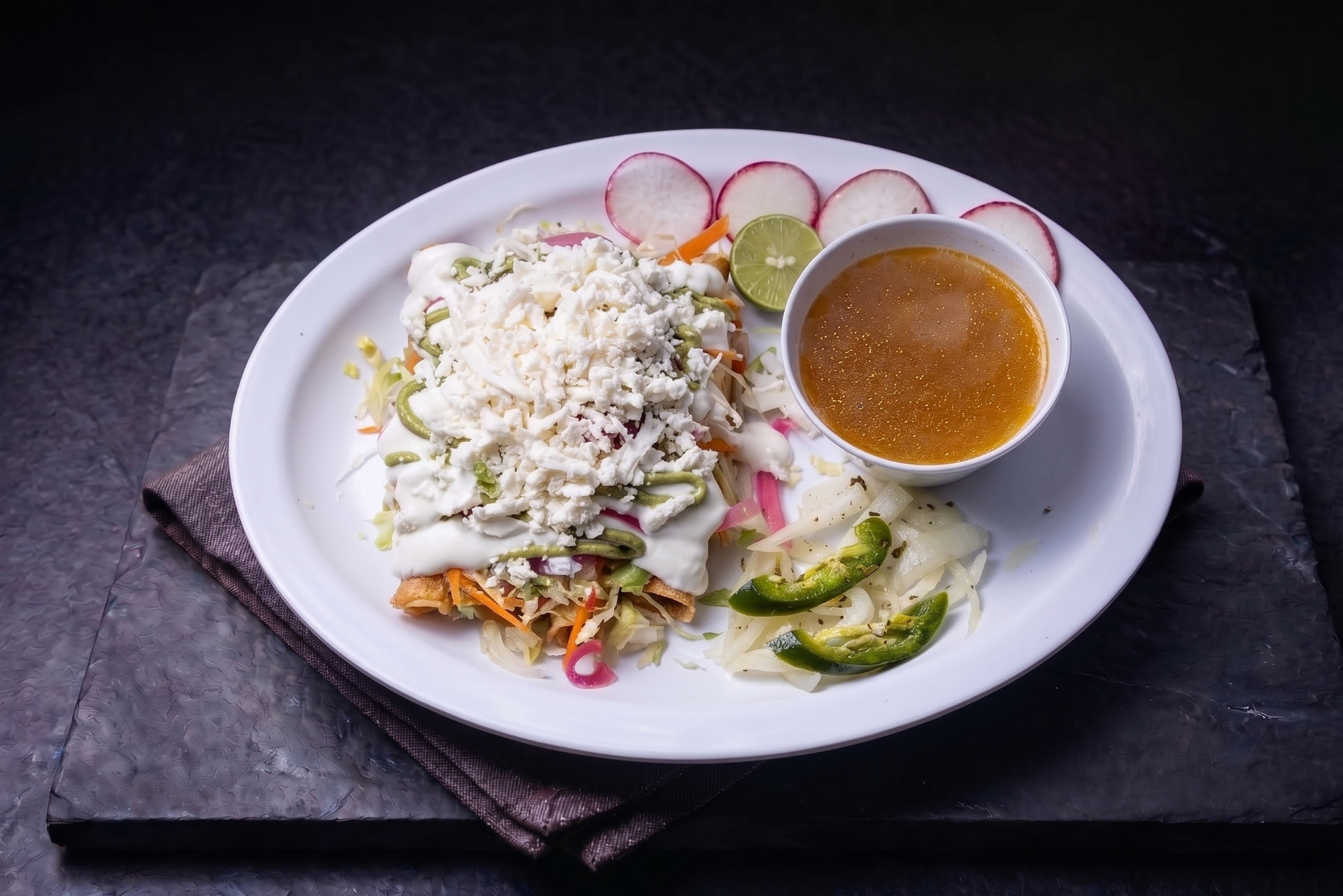 Flautas de papa o deshebrada doradas con queso fresco, crema, lechuga y salsa
